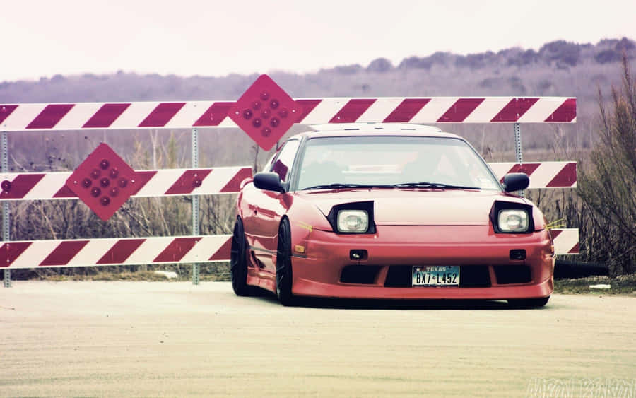 A Red Car Parked In Front Of A Fence Wallpaper