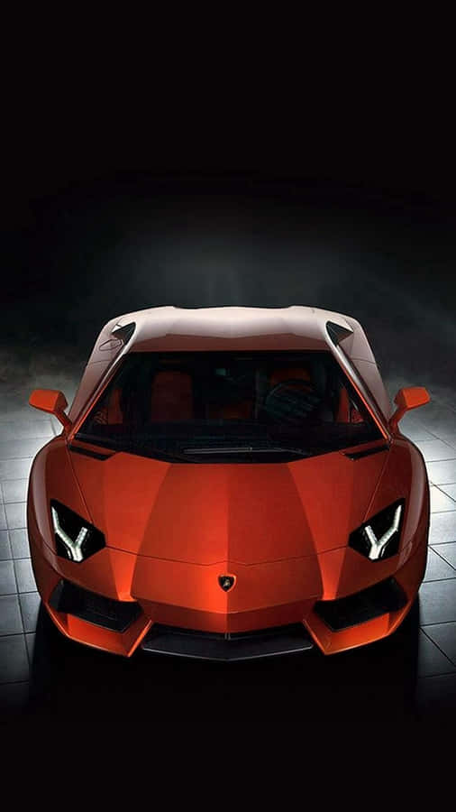 A Red Sports Car Is Shown In A Dark Room Wallpaper
