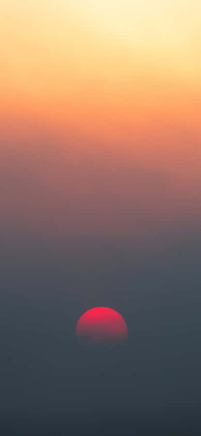 A Red Sun Rising Over A Fog Filled Sky Wallpaper