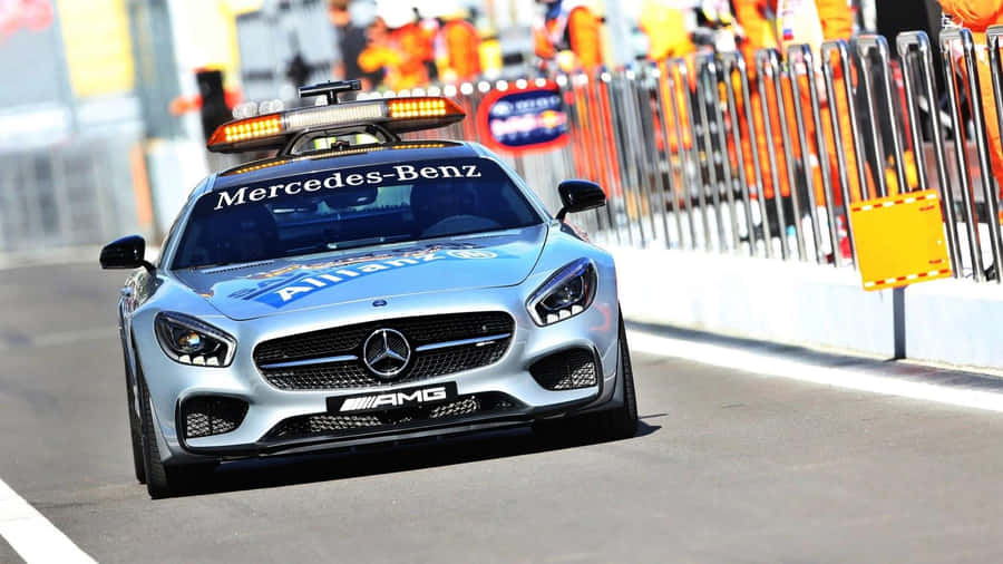 A Safety Car Leading The Race On A Track Wallpaper