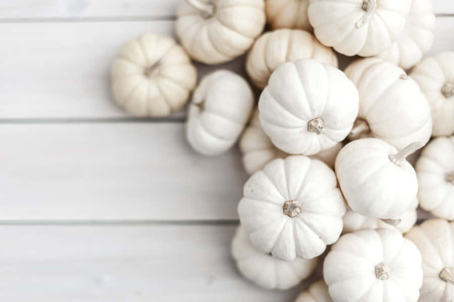 A Scenic View Of Autumn Bounty With Pumpkins, Apples, And Colorful Leaves Wallpaper