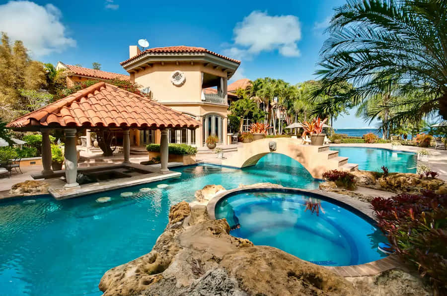A Serene Beach Swimming Pool Surrounded By Palm Trees And Lounge Chairs Wallpaper
