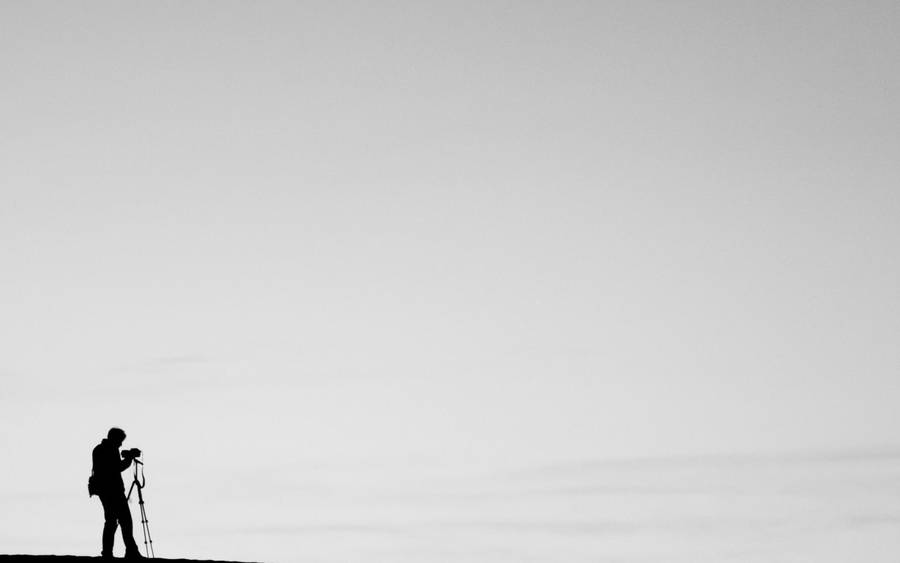 A Silhouette Of A Minimal Photographer Wallpaper