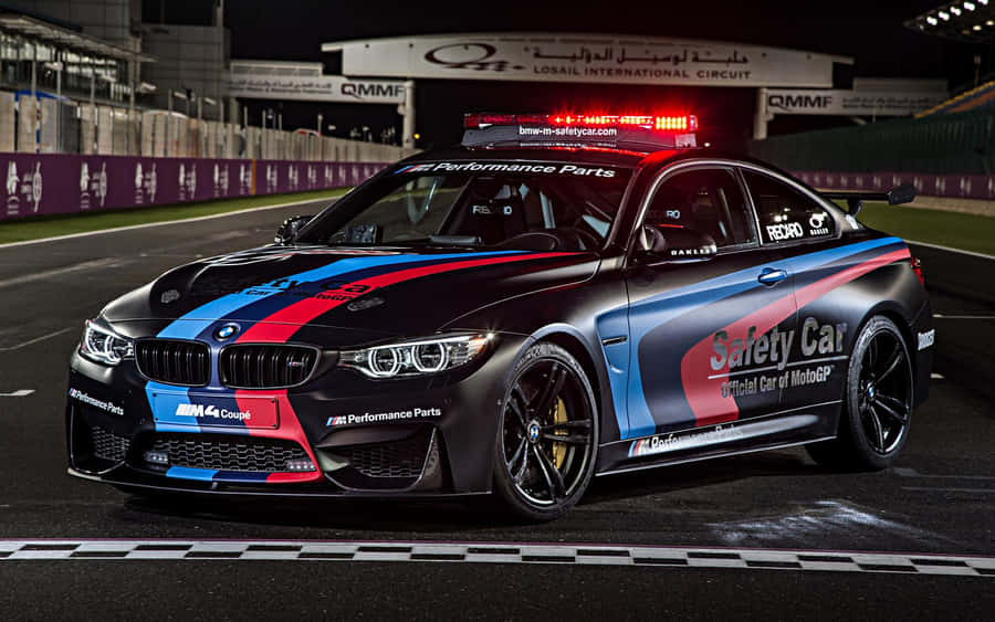 A Sleek And Modern Safety Car Leading The Race On The Track Wallpaper