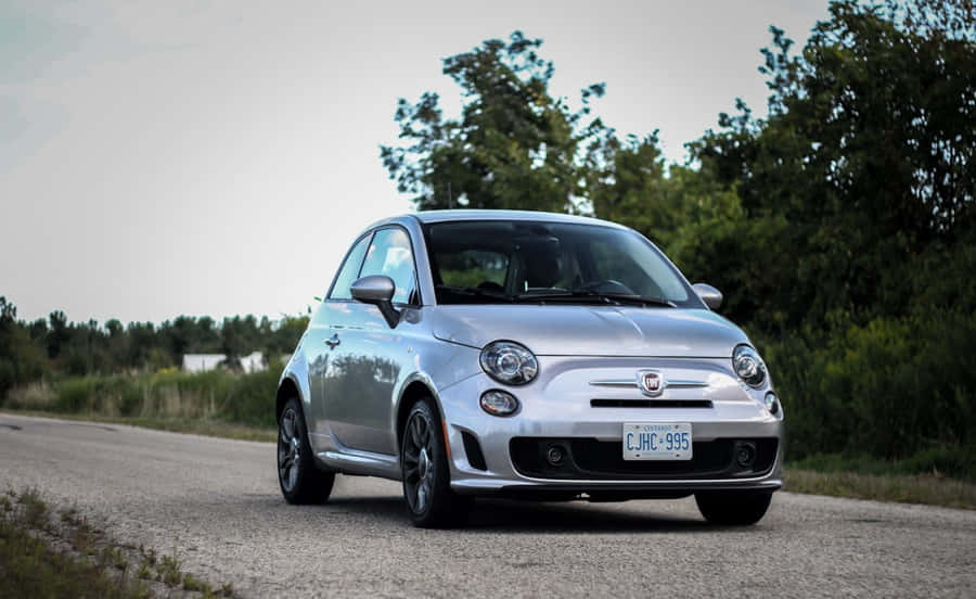 A Sleek And Stylish Red Fiat 500 Parked On A City Street Wallpaper