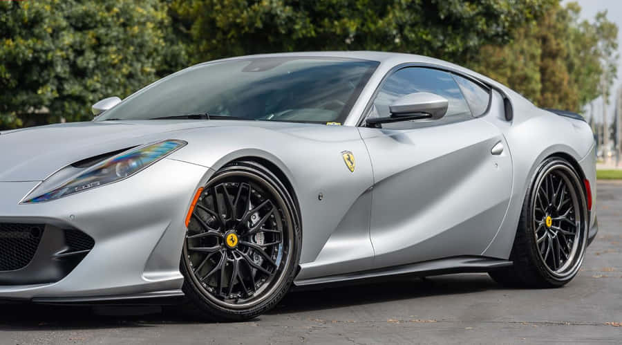 A Sleek Red Beauty, The Ferrari 812 Superfast Speeds Past The Open Road And Awes The Onlookers. Wallpaper