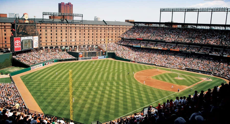 A Spectacular Panoramic View Of A Baseball Stadium During Sunset Wallpaper