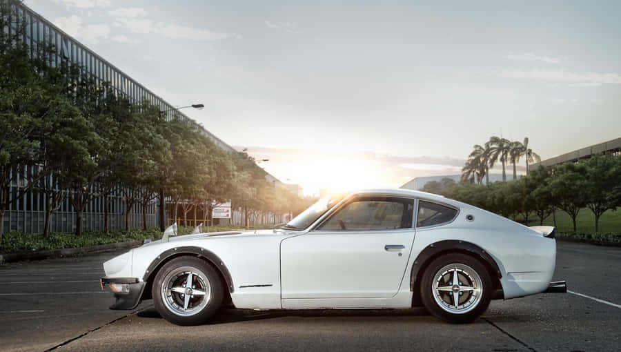 A Stunning Blue Datsun In A Radiant Outdoor Setting Wallpaper