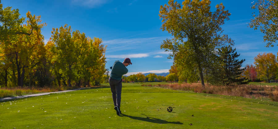 A Stunning View Overlooking A Pristine Golf Green On A Sunny Day Wallpaper