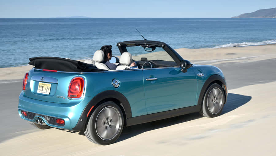 A Stylish Mini Cooper Convertible Parked By The Beachside. Wallpaper