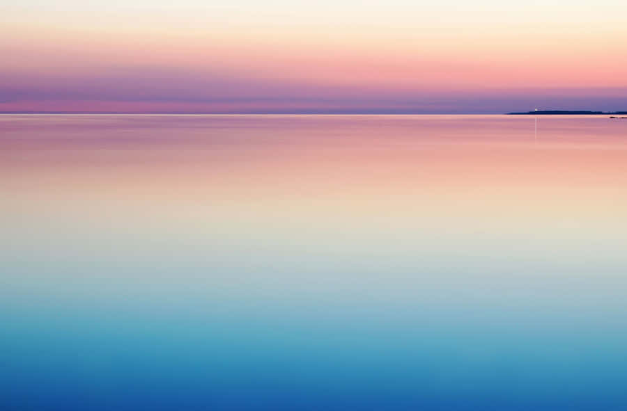 A Sunset Over A Calm Body Of Water Wallpaper