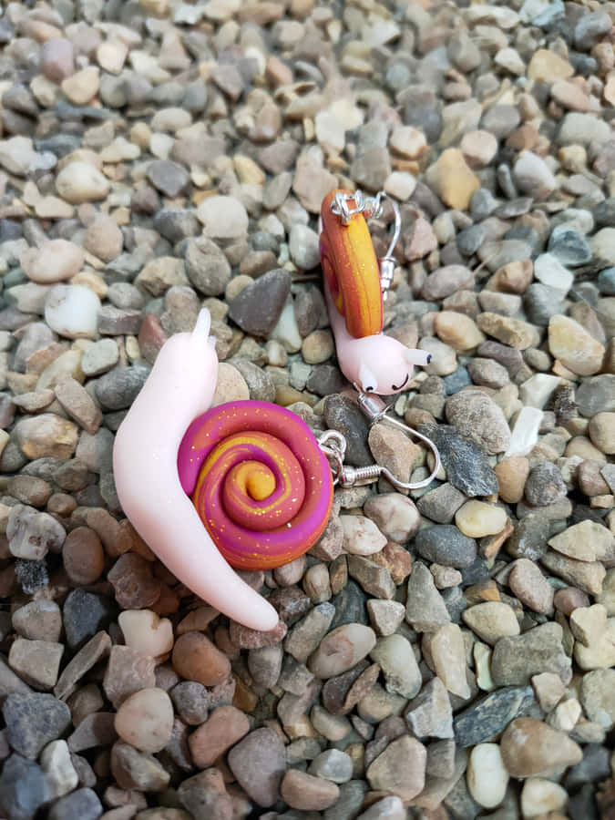 A Vibrant Pink Snail Crawling On A Green Leaf Wallpaper