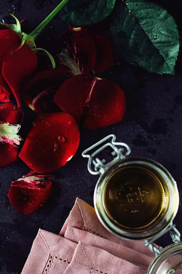 A Vibrant Rose Surrounded By Essential Oil Droplets Wallpaper