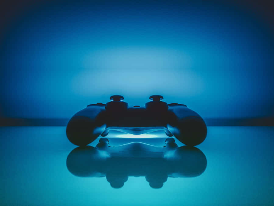 A Video Game Controller Is Sitting On A Blue Surface Wallpaper