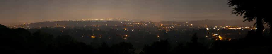 A View Of A City At Night With Lights Wallpaper