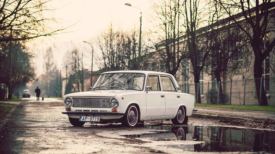 A Vintage Car In The Street Of Riga Wallpaper