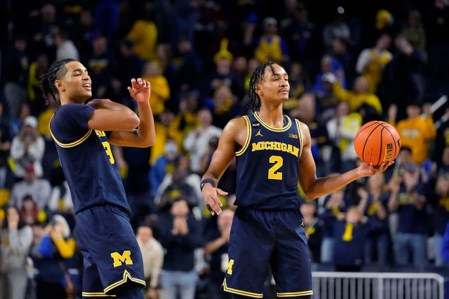 Action Shot Of Jett Howard Playing Basketball Wallpaper