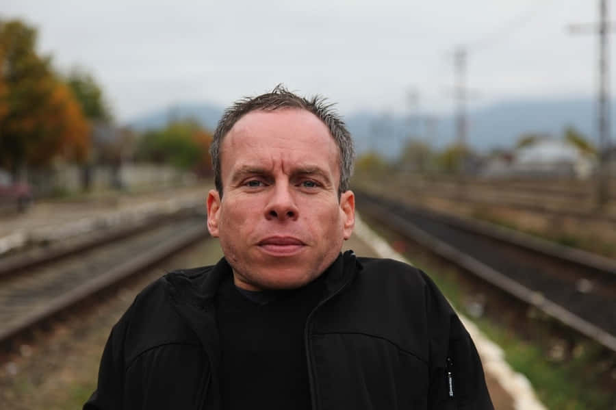 Actor Warwick Davis Posing At An Event Wallpaper