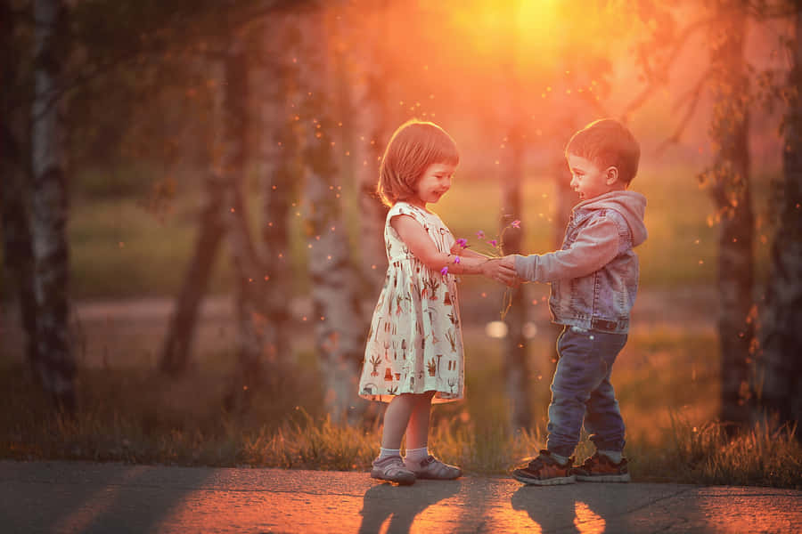 Adorable Toddlers Laughing And Bonding Outdoors Wallpaper