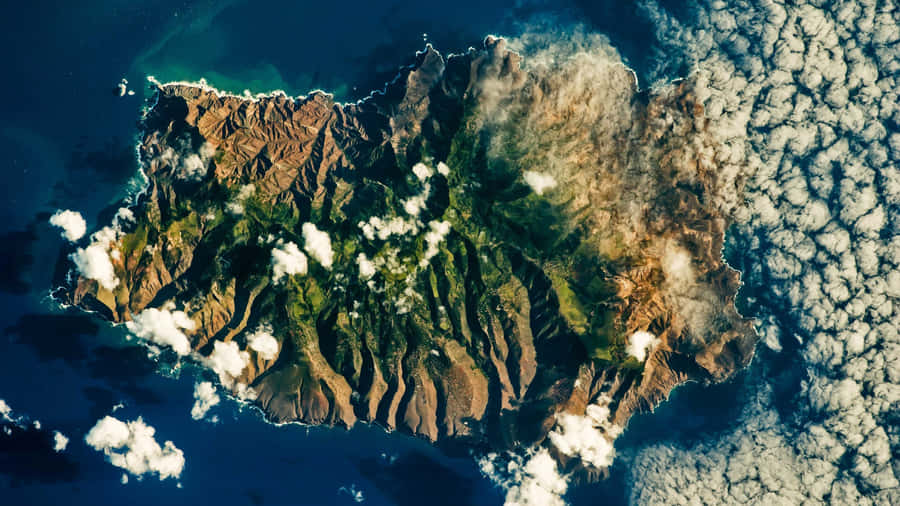 Aerial_ View_of_ Rugged_ Island_ Amidst_ Clouds_4 K Wallpaper