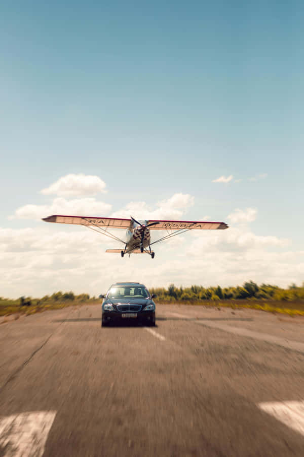 Airplane Landing Above Car Wallpaper