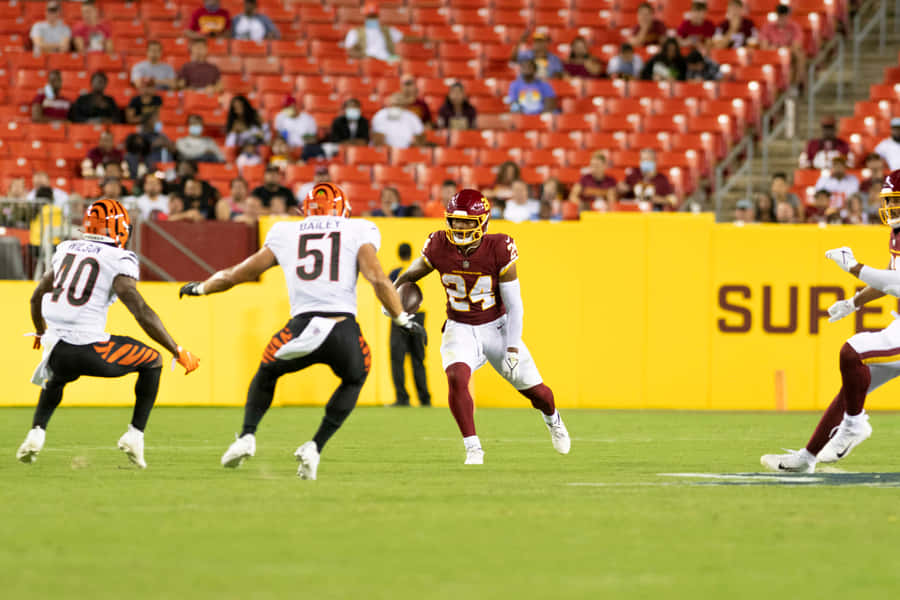 Antonio Gibson Evading Defenders During Game Wallpaper