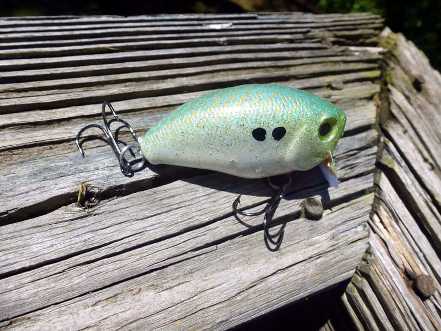 Assortment Of Colorful Fishing Bait On A Wooden Table Wallpaper