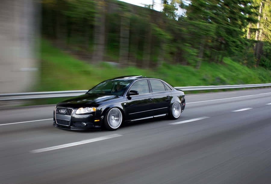 Audi Rs4 Racing Through Forest Road Wallpaper