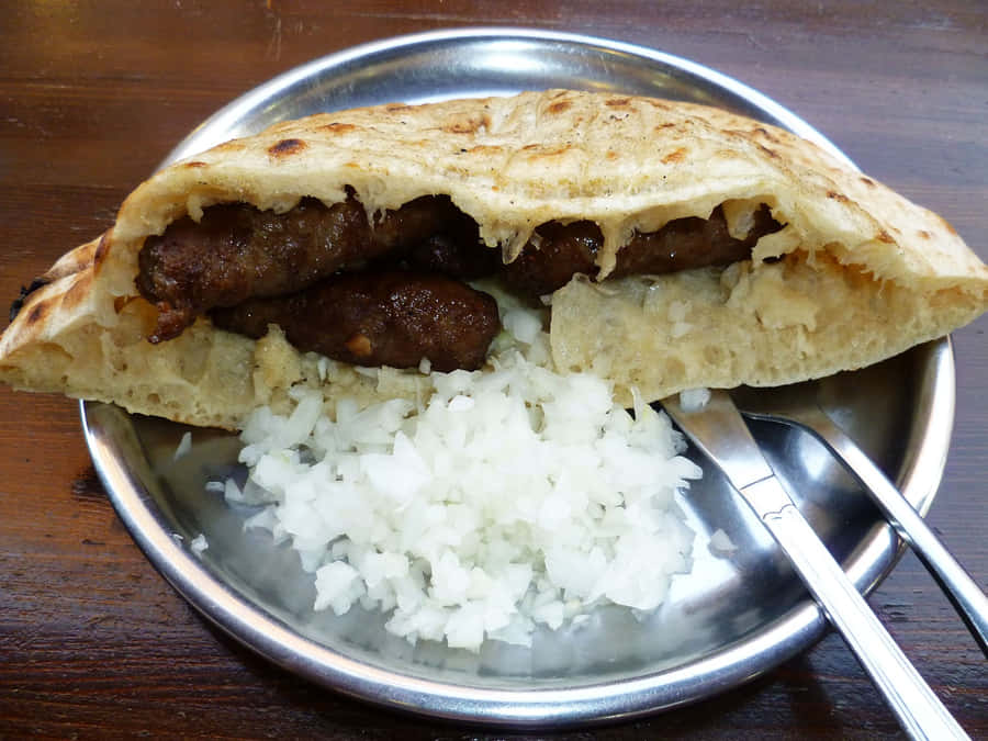 Authentic Balkan Cevapi Served In Fluffy Pita Bread Wallpaper