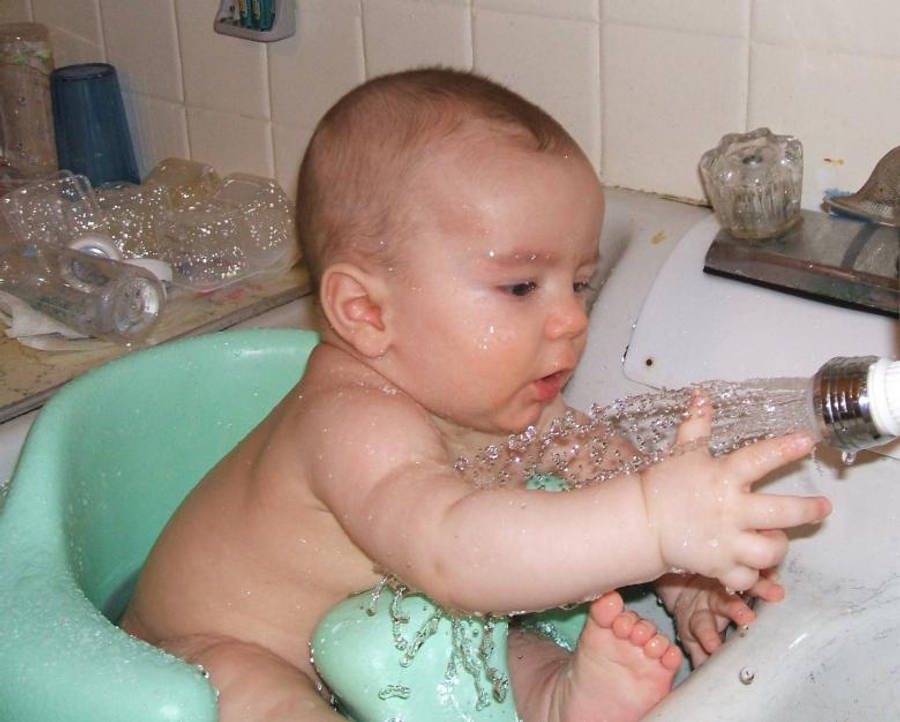 Baby Boy Playing With Water Wallpaper