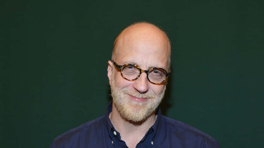 Bald Manwith Glasses Smiling Wallpaper