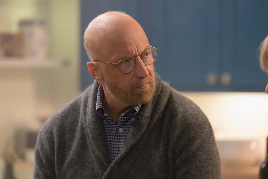 Balding Manin Glassesand Grey Coat Wallpaper