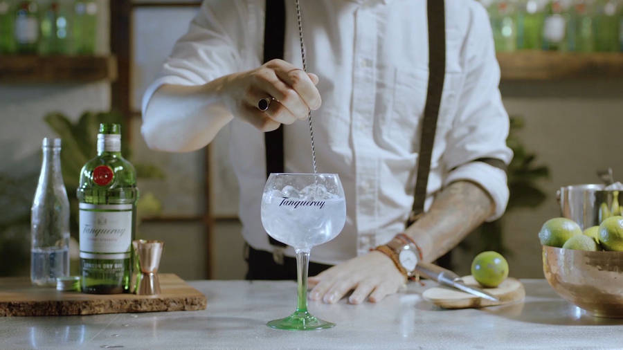 Bartender Mixing Tanqueray Gin With Tonic Wallpaper