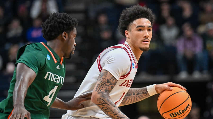 Basketball Player Dribbling Past Opponent Wallpaper