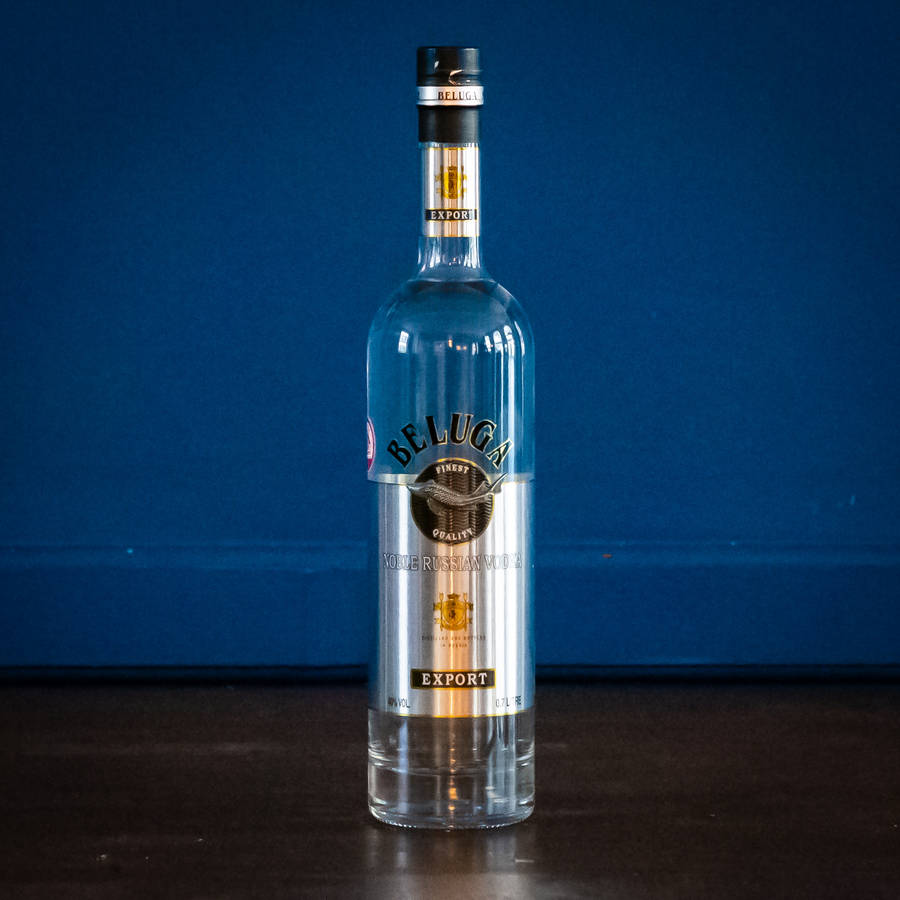 Beluga Vodka Glass Bottle On Blue Backdrop Wallpaper