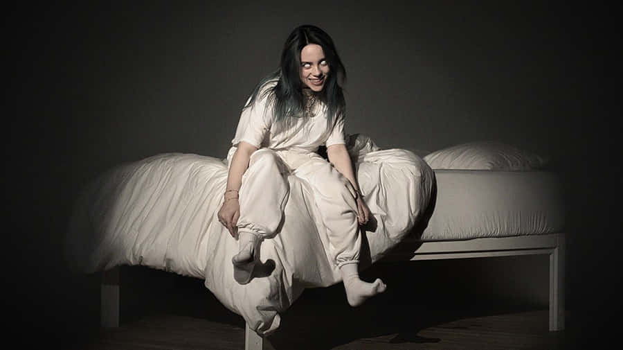 Billie Eilish Typing Away On Her Laptop Wallpaper