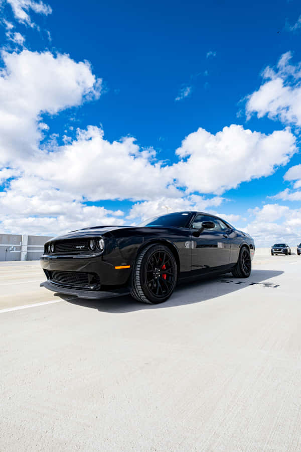 Black Muscle Car Under Cloudy Sky Wallpaper