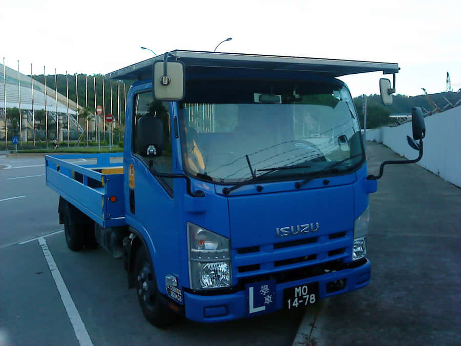 Blue Isuzu Elf Truck Parked Wallpaper