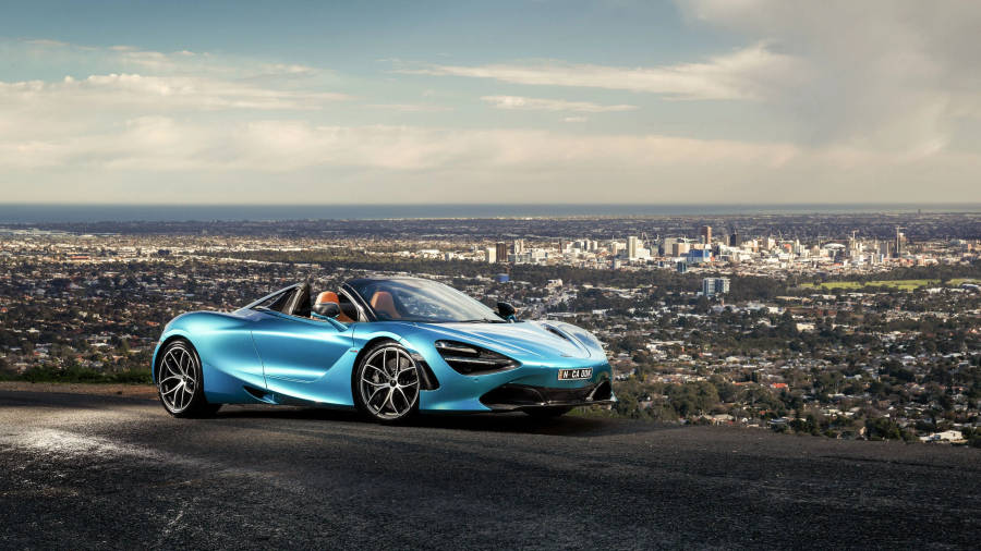 Blue Mclaren Spyder Near City Wallpaper