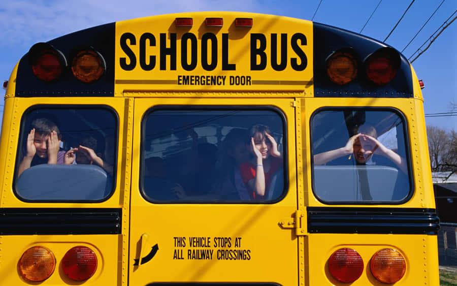 Bright Yellow School Bus Parked Outdoors Wallpaper