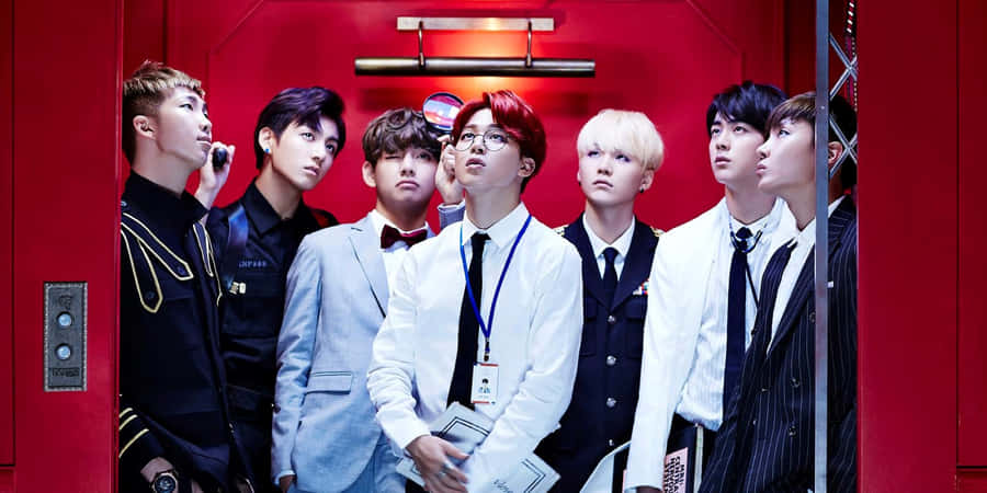 Bts Band Members In Vibrant Attire Against Urban Background Wallpaper