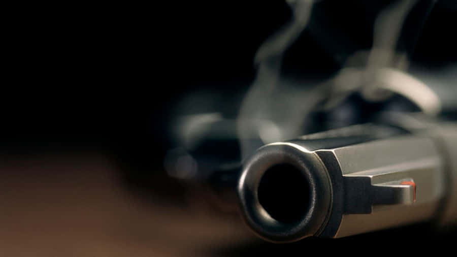Caption: A Figure Holding A Smoking Gun Wallpaper