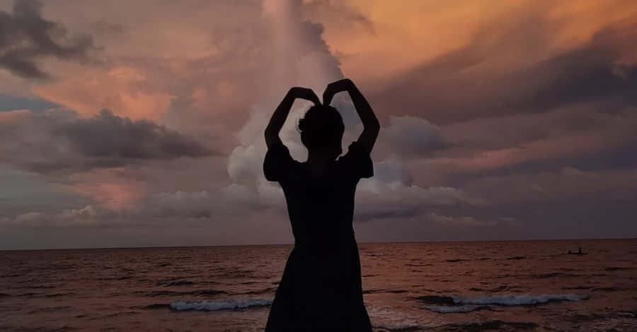 Caption: A Romantic Heart Silhouette Against A Gradient Sunset Wallpaper