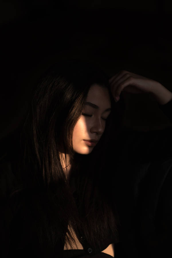 Caption: Elegant Dark-skinned Girl Illuminated By Sunlight Wallpaper