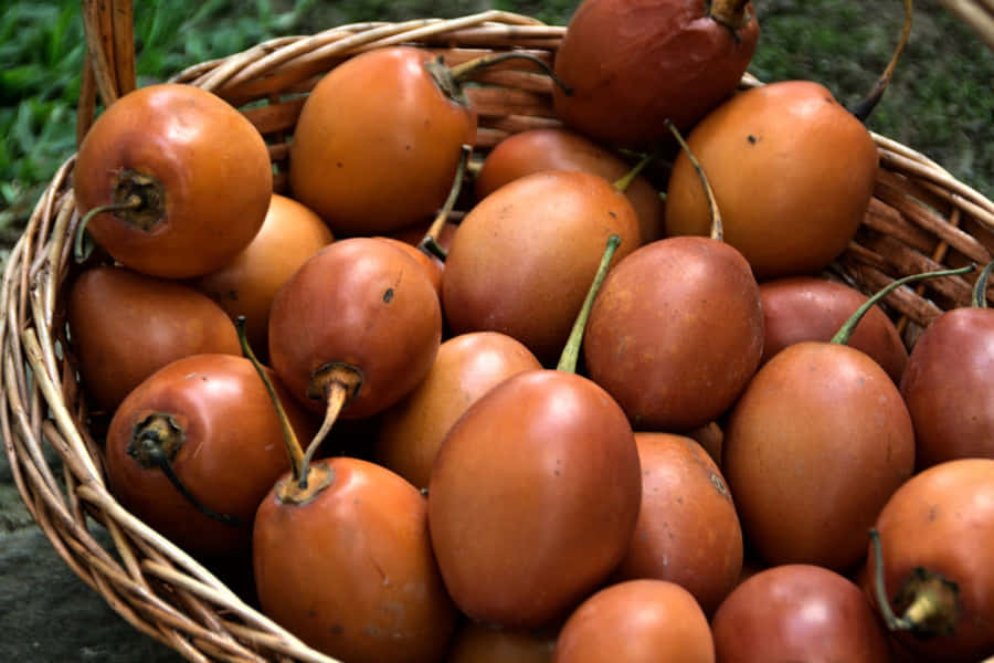 Caption: Exotic Tamarillo Fruits In A Rustic Basket Wallpaper