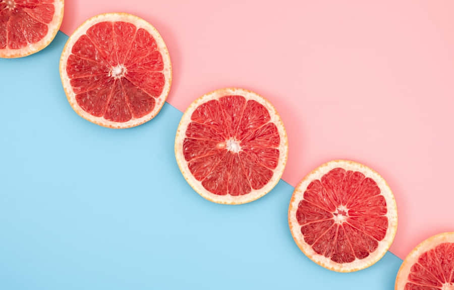 Caption: Fresh And Juicy Pink Grapefruit Wallpaper