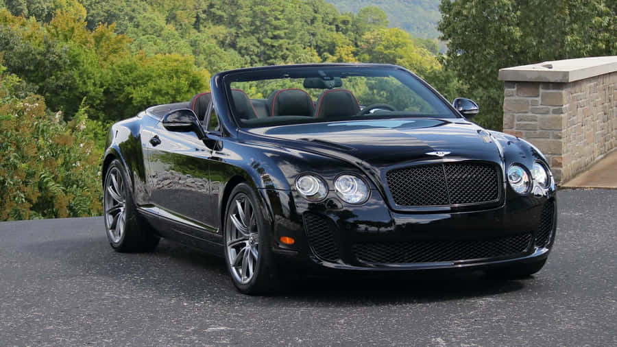 Caption: Sleek Bentley Continental Supersports On An Open Road Wallpaper