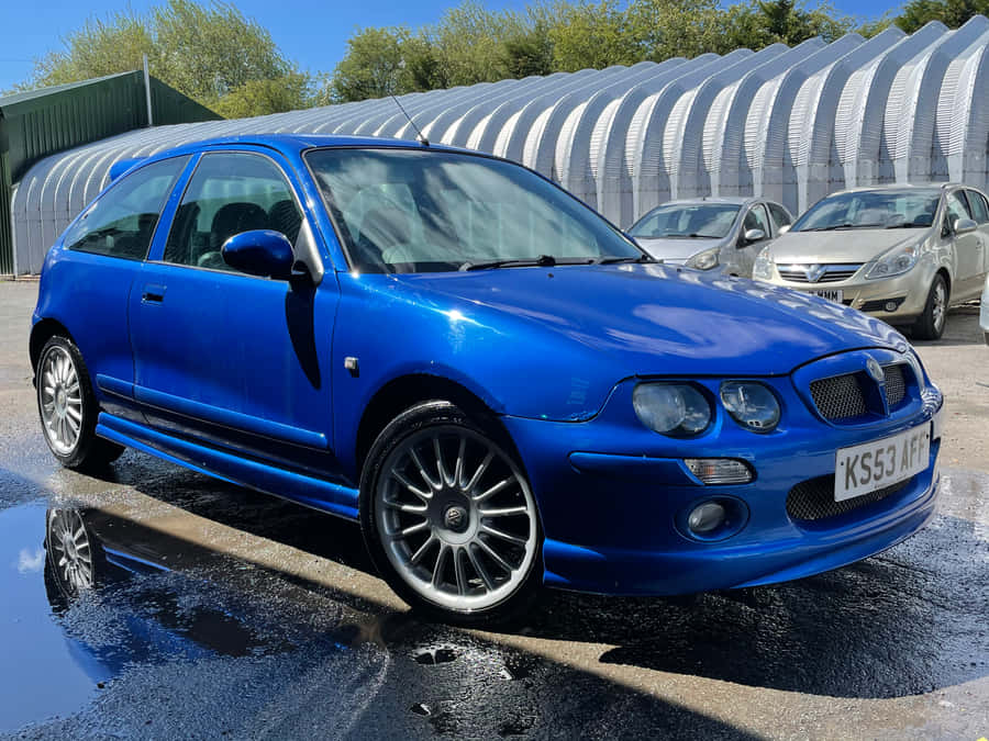Caption: Sleek Silver Mg Zr Glinting Under A Bright Blue Sky Wallpaper