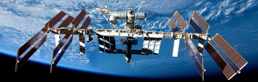 Caption: Stunning View Of The International Space Station Orbiting Earth Wallpaper
