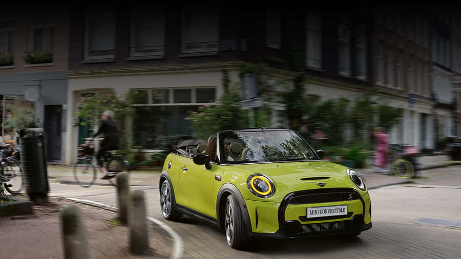 Caption: Vibrant Mini Cooper Convertible Cruising On A Sunny Day Wallpaper